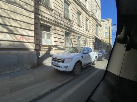 歩道に乗り上げる自動車の写真