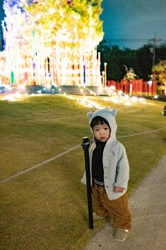 冬のイルミネーションの前に立つお子さん