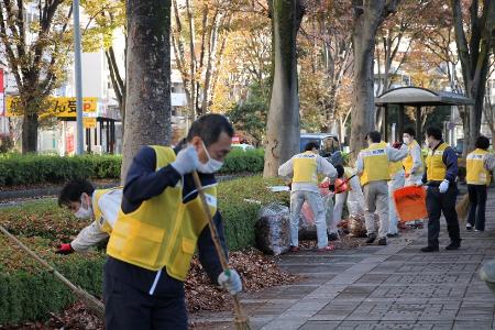 集めた落ち葉を袋に入れる様子