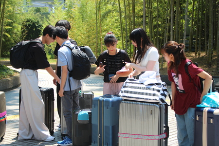 学生たちが荷物を抱え集まっている