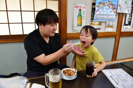 子どもが大きなお口を開けて食事を楽しんでいる