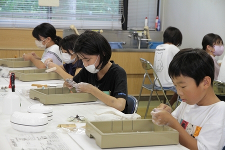 まが玉を磨いている子どもたち